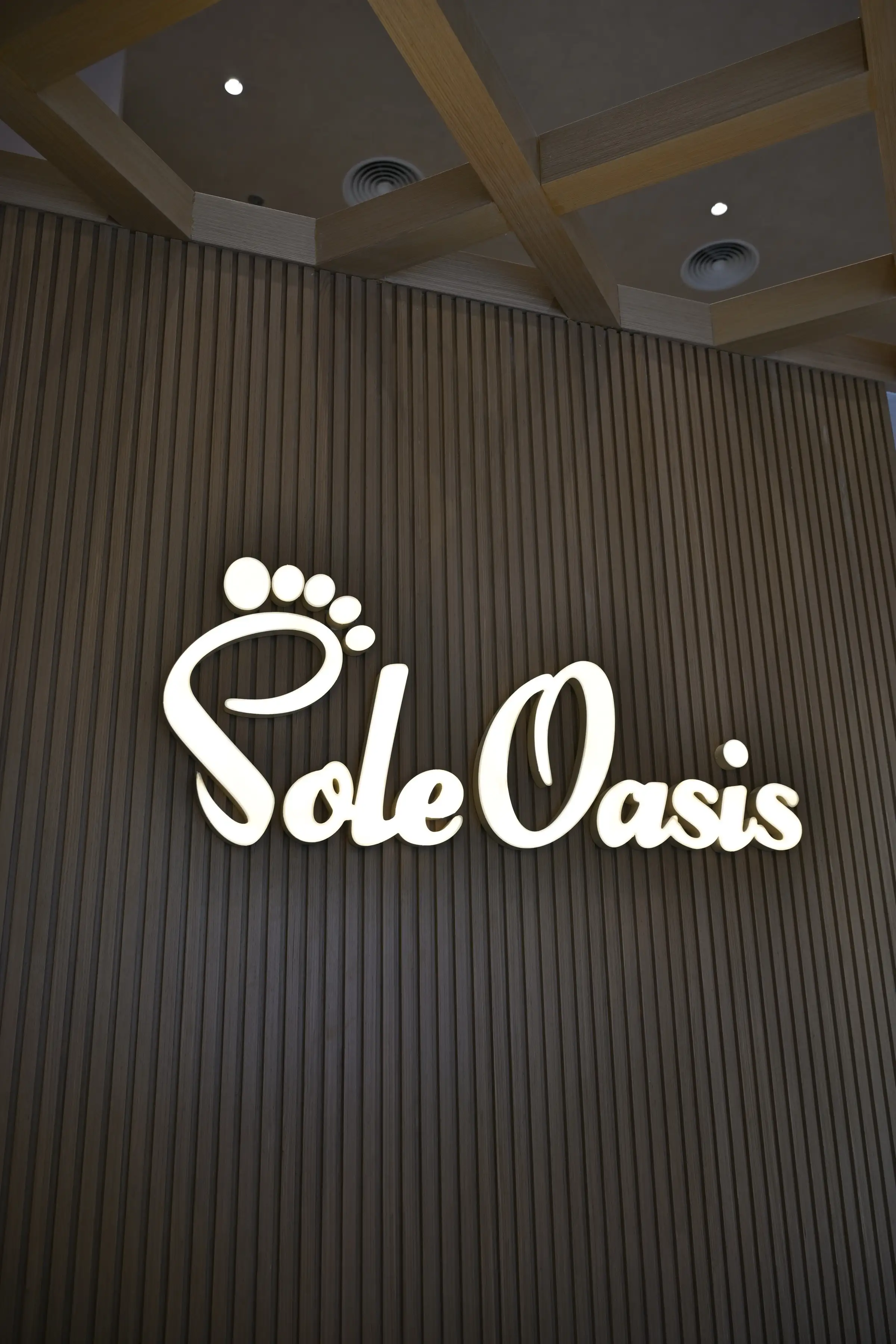 Illuminated Sole Oasis sign glowing above the marble reception
